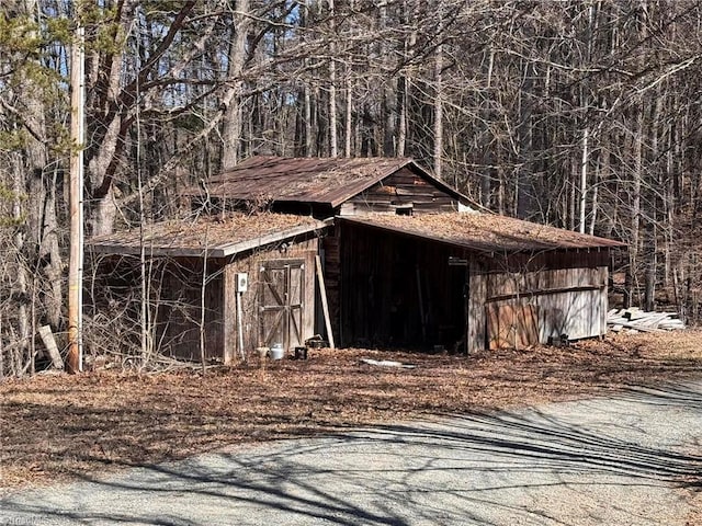 view of outdoor structure featuring an outbuilding and a wooded view