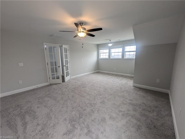 carpeted empty room with french doors, baseboards, and ceiling fan