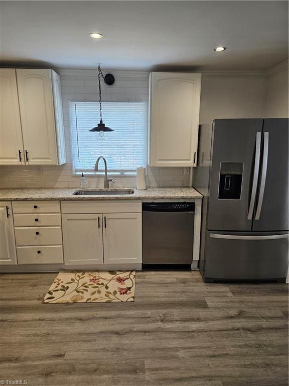 kitchen with a sink, light wood-type flooring, white cabinetry, and stainless steel appliances