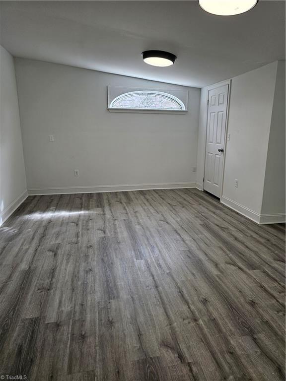 interior space with dark wood finished floors and baseboards