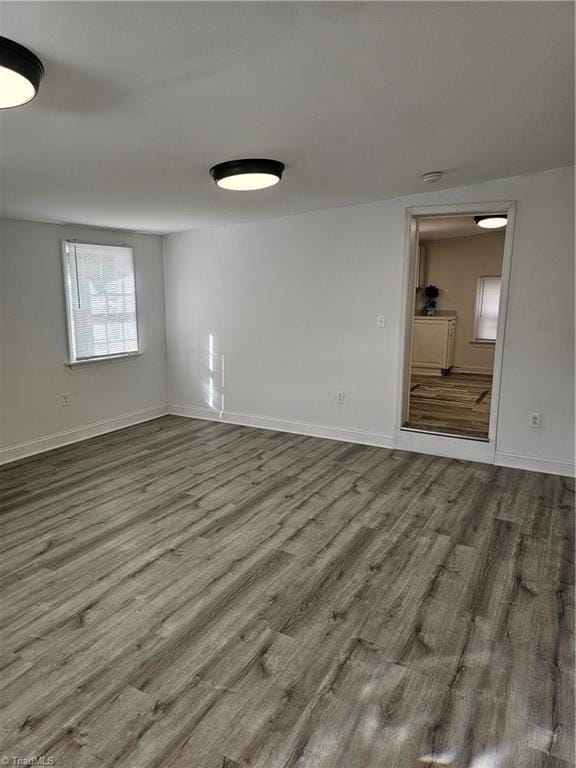 unfurnished room with baseboards and wood finished floors