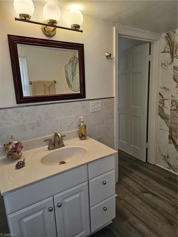 bathroom with tile walls, vanity, and wood finished floors