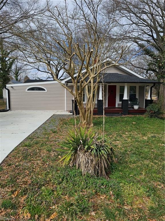 bungalow with a porch, concrete driveway, and a front yard