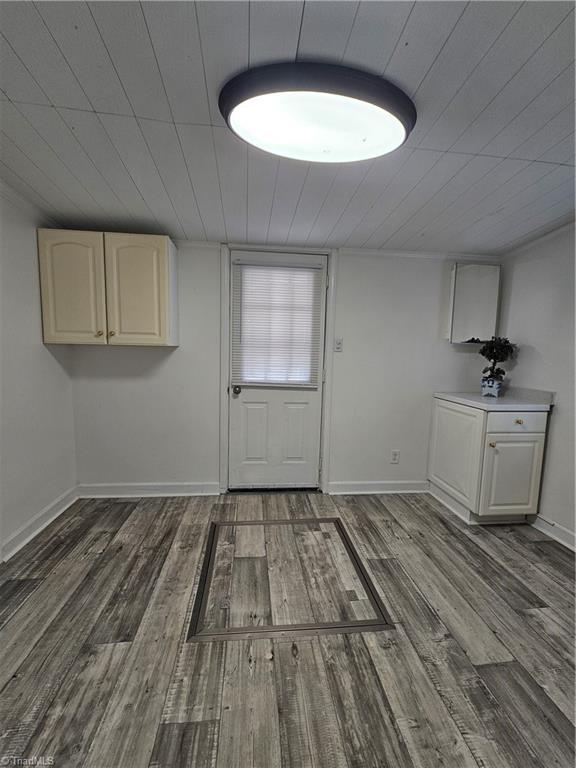 interior space featuring baseboards and wood finished floors