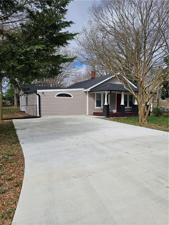 view of front of property with driveway and a chimney