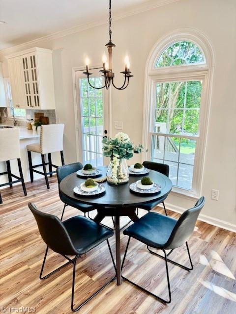 121 Spring Lake Ct, Lexington, NC 27295 - dining area with a chandelier, plenty of natural light, ornamental molding, and light wood-style flooring
