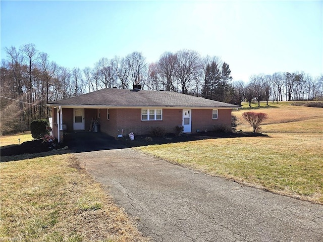 single story home with brick siding, driveway, and a front lawn