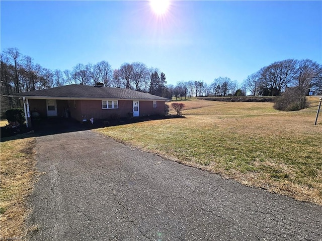 view of home's exterior featuring aphalt driveway and a lawn