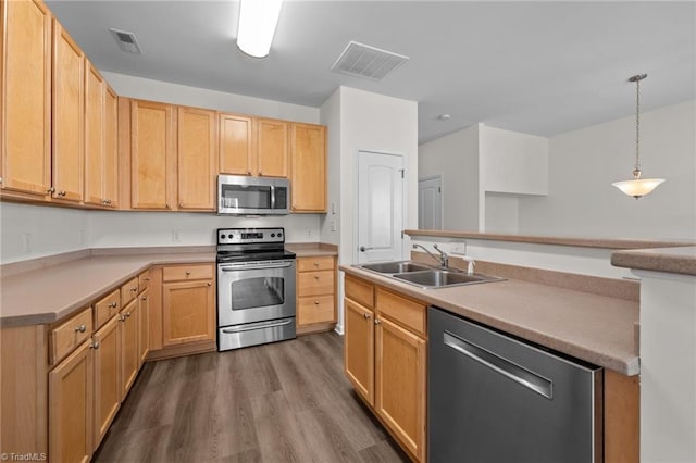 kitchen with visible vents, a sink, dark wood-type flooring, and stainless steel appliances