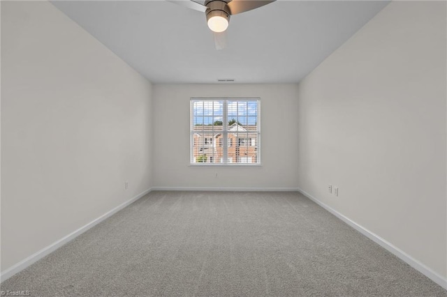 spare room with baseboards, light colored carpet, ceiling fan, and visible vents