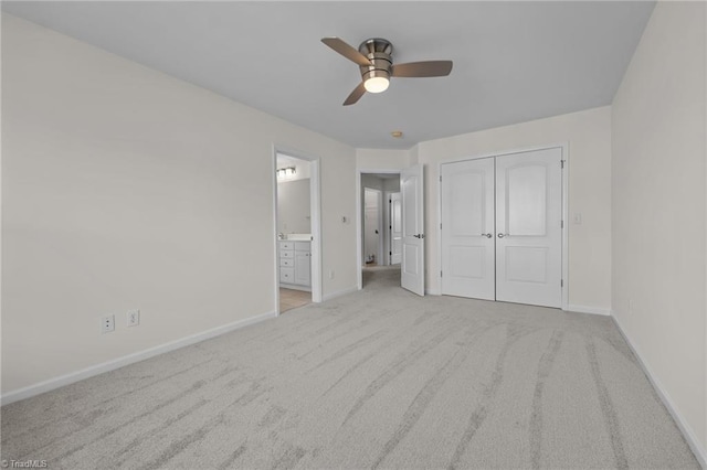unfurnished bedroom featuring connected bathroom, baseboards, carpet, and a closet