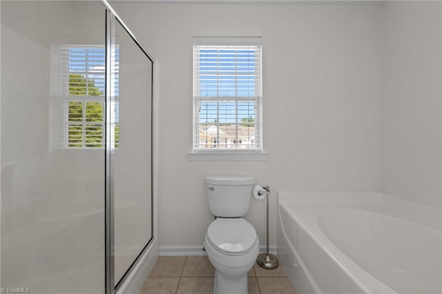 bathroom with baseboards, tile patterned flooring, a stall shower, and a garden tub