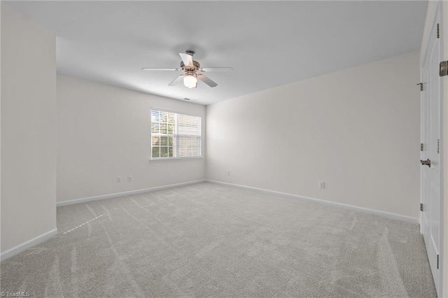 unfurnished room with baseboards, ceiling fan, and light carpet