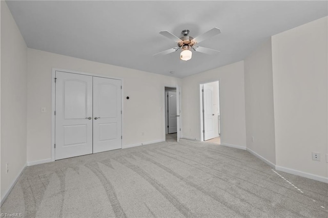 unfurnished bedroom with carpet floors, baseboards, a ceiling fan, and a closet