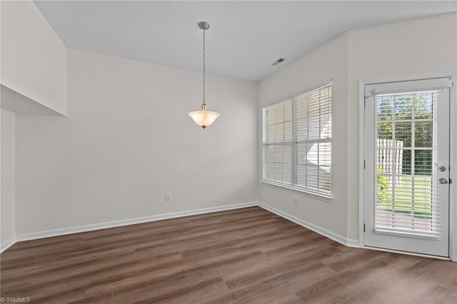 unfurnished dining area with baseboards, wood finished floors, and visible vents