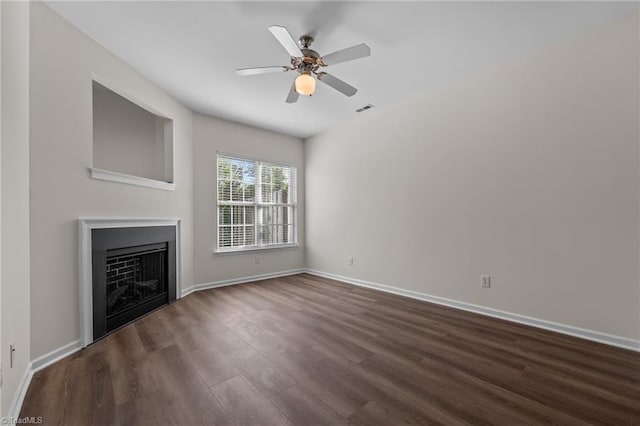 unfurnished living room featuring baseboards, visible vents, dark wood-style floors, and a fireplace