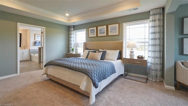 bedroom featuring light carpet, ensuite bathroom, a raised ceiling, and multiple windows