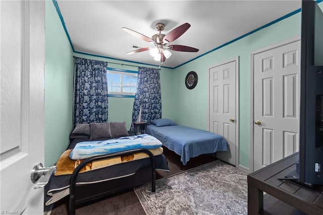 carpeted bedroom featuring ceiling fan and ornamental molding