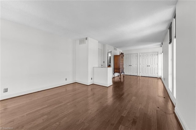 unfurnished living room featuring dark hardwood / wood-style flooring