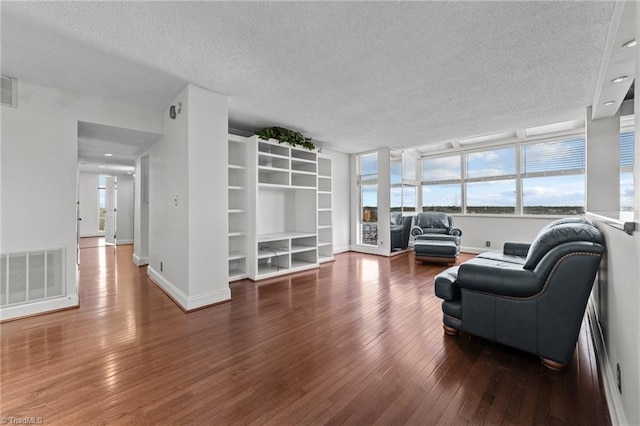 living room featuring a textured ceiling and dark wood-type flooring