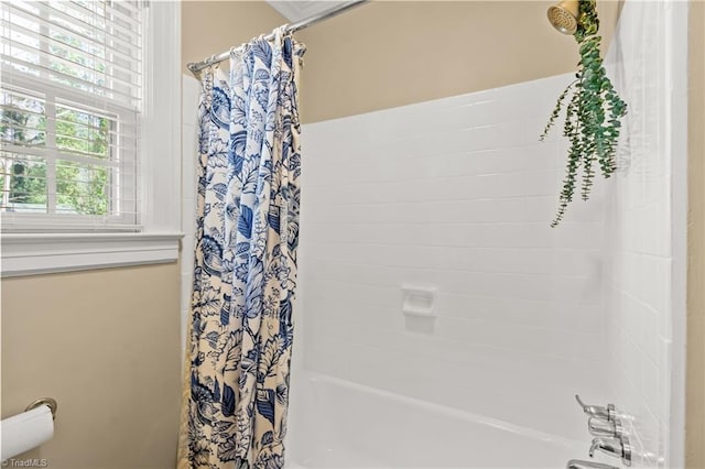 bathroom with a healthy amount of sunlight and shower / tub combo with curtain