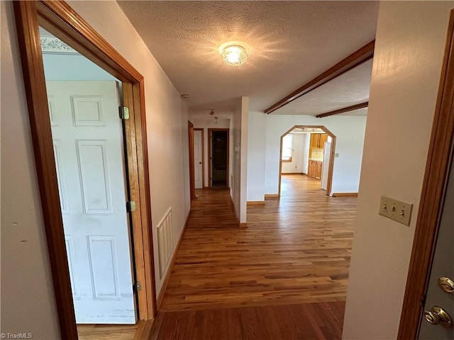 hallway featuring light hardwood / wood-style flooring and a textured ceiling