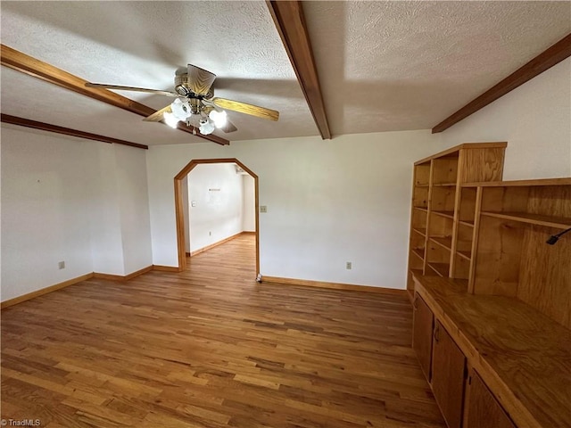 unfurnished room featuring a textured ceiling, wood-type flooring, and ceiling fan