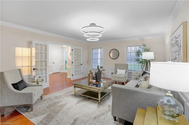 living room with french doors, light hardwood / wood-style floors, and ornamental molding