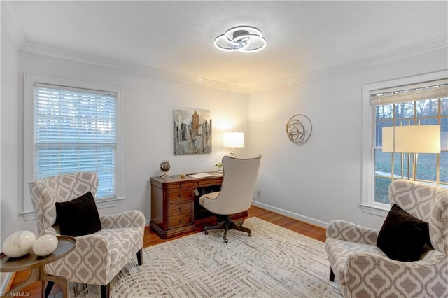 home office with a healthy amount of sunlight, light wood-type flooring, and ornamental molding