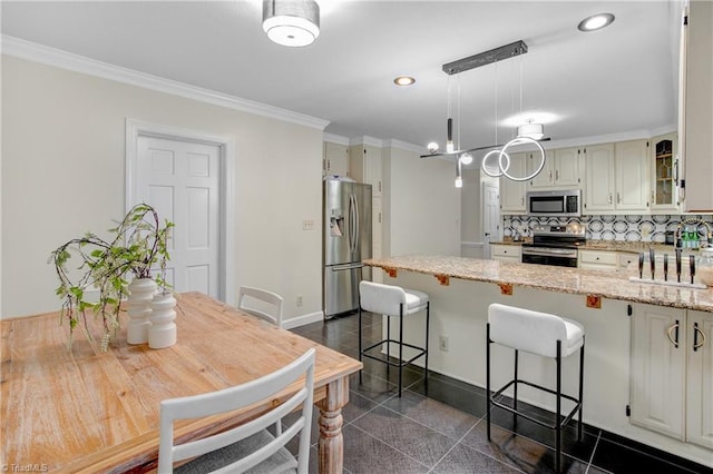 kitchen featuring light stone countertops, appliances with stainless steel finishes, decorative light fixtures, and crown molding