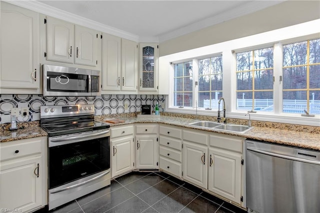 kitchen with stainless steel appliances, white cabinetry, tasteful backsplash, and sink