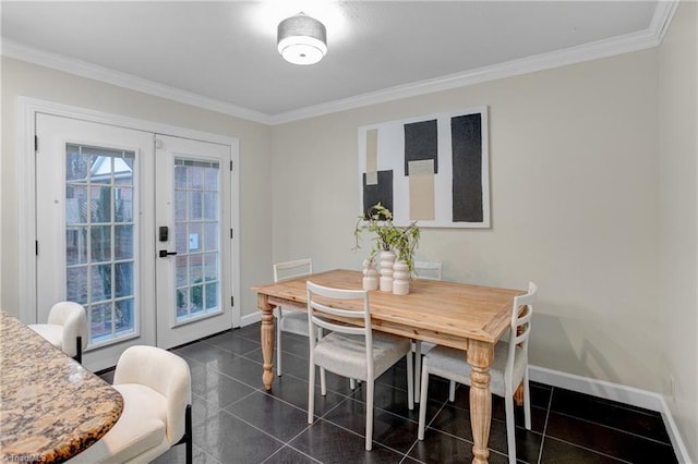 dining room featuring dark tile patterned flooring, crown molding, and french doors