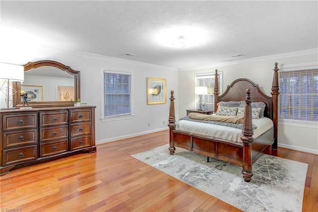 bedroom featuring a textured ceiling, light hardwood / wood-style floors, and crown molding