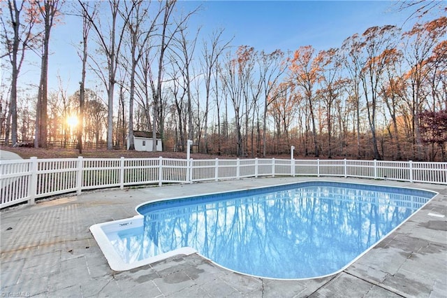 pool at dusk featuring a patio