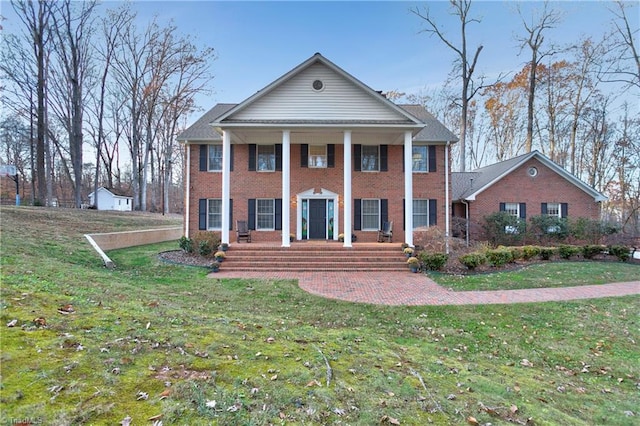 greek revival inspired property featuring a shed and a front lawn