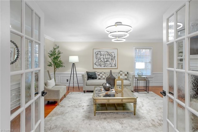 living room with french doors, ornamental molding, and hardwood / wood-style flooring