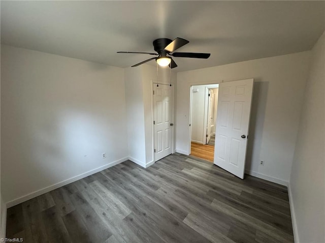 unfurnished bedroom featuring a ceiling fan, dark wood finished floors, and baseboards