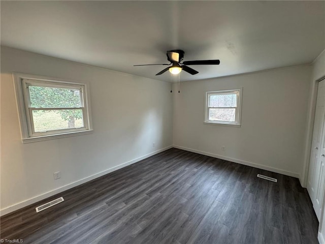 unfurnished bedroom featuring baseboards, visible vents, ceiling fan, and dark wood-type flooring