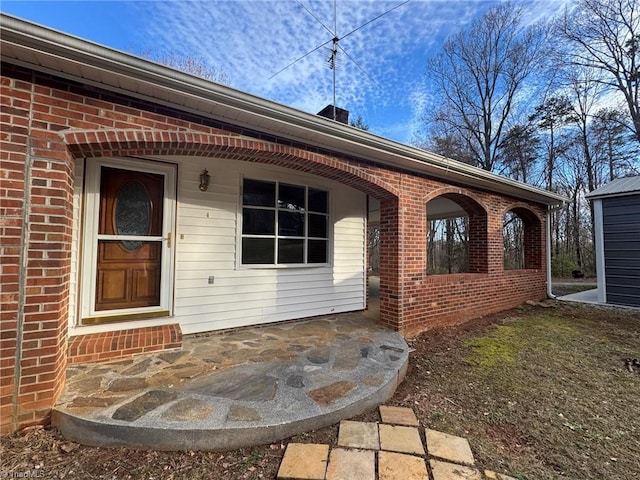 doorway to property with brick siding