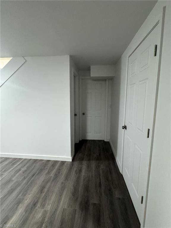 hall with dark wood finished floors and baseboards