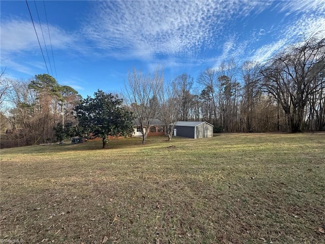 view of yard with a garage and an outbuilding