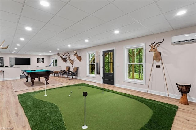 recreation room featuring an AC wall unit, wood finished floors, baseboards, and recessed lighting