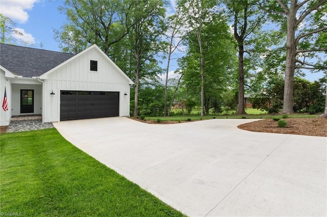 view of property exterior with board and batten siding, driveway, a yard, an attached garage, and a shingled roof