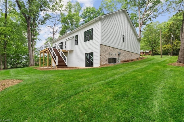 back of property with stairs, a yard, cooling unit, and a deck