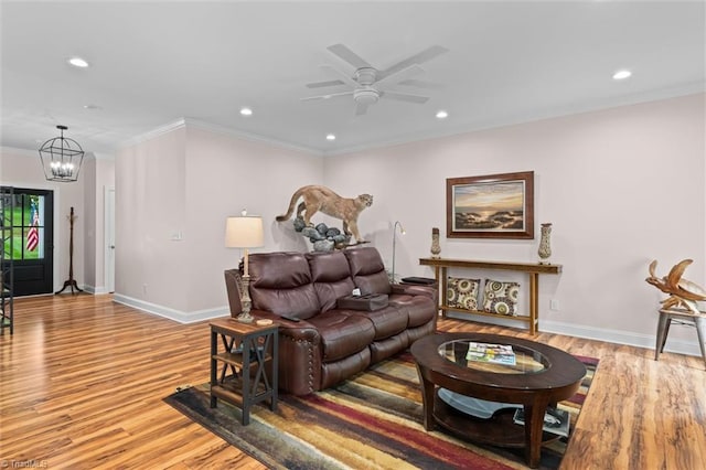 living area with light wood finished floors, crown molding, a chandelier, recessed lighting, and a ceiling fan