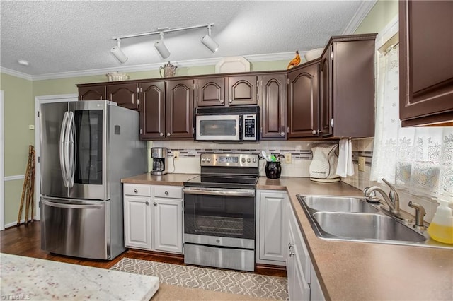 kitchen with appliances with stainless steel finishes, tasteful backsplash, ornamental molding, a textured ceiling, and sink