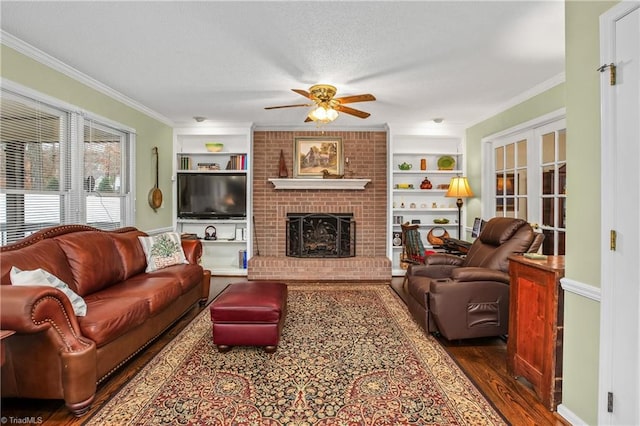 living room featuring dark wood-type flooring, french doors, a brick fireplace, ceiling fan, and ornamental molding