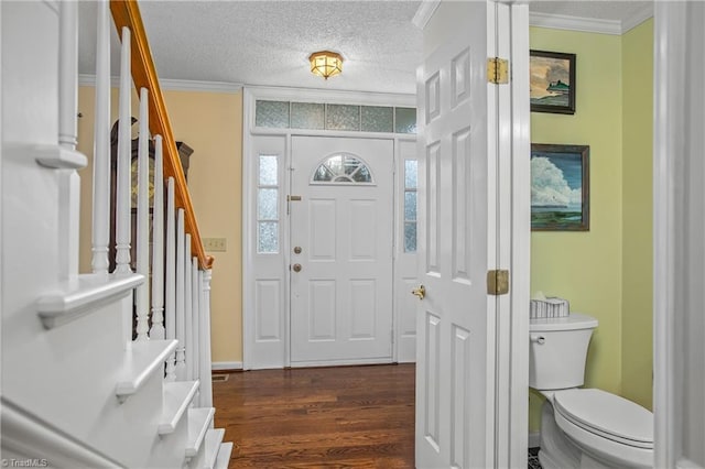 entryway with a textured ceiling, dark hardwood / wood-style floors, and crown molding