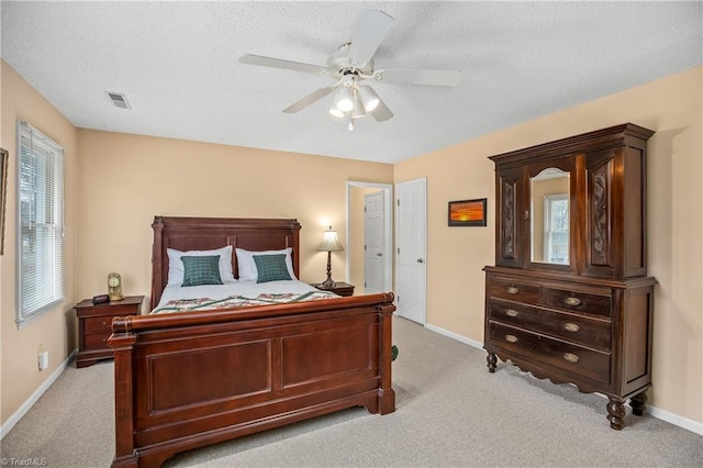 carpeted bedroom featuring ceiling fan and a textured ceiling