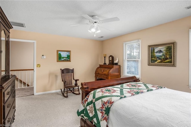 carpeted bedroom featuring ceiling fan and a textured ceiling